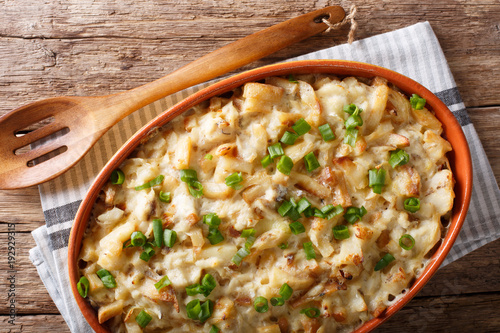 Bacalhau com natas - baked cod with potatoes, onions and cream closeup. horizontal top view