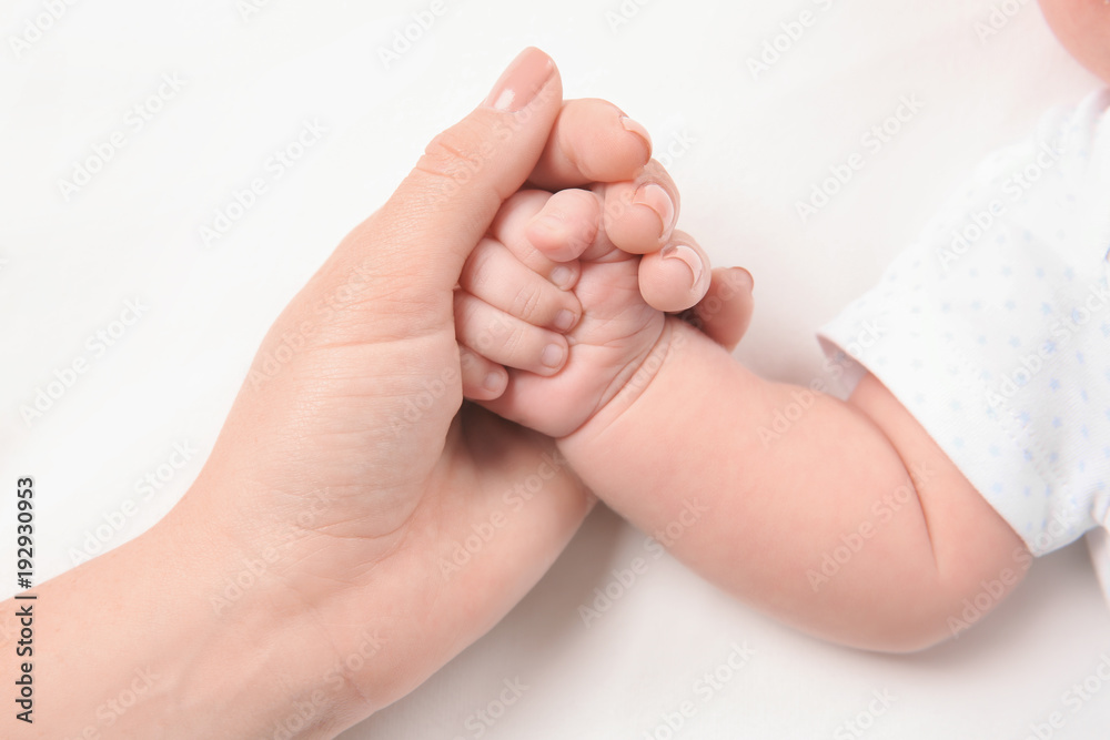 Mother holding newborn baby's hand on white background, closeup Mother holding newborn baby's hand on white background, closeup