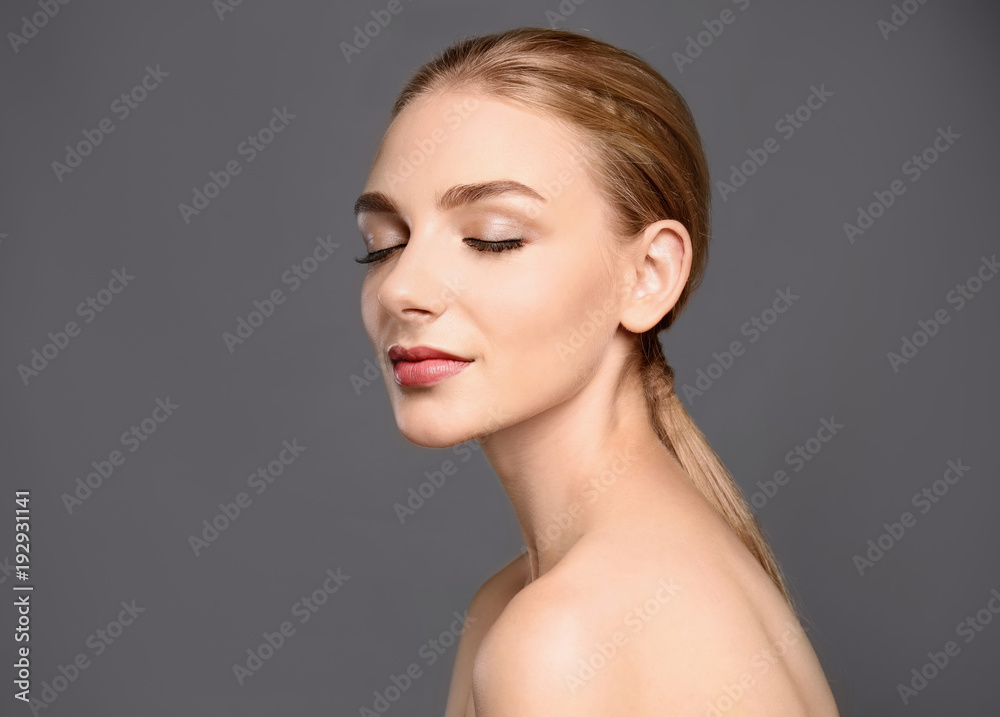 Portrait of beautiful young woman with clear skin on grey background Portrait of beautiful young woman with clear skin on grey background