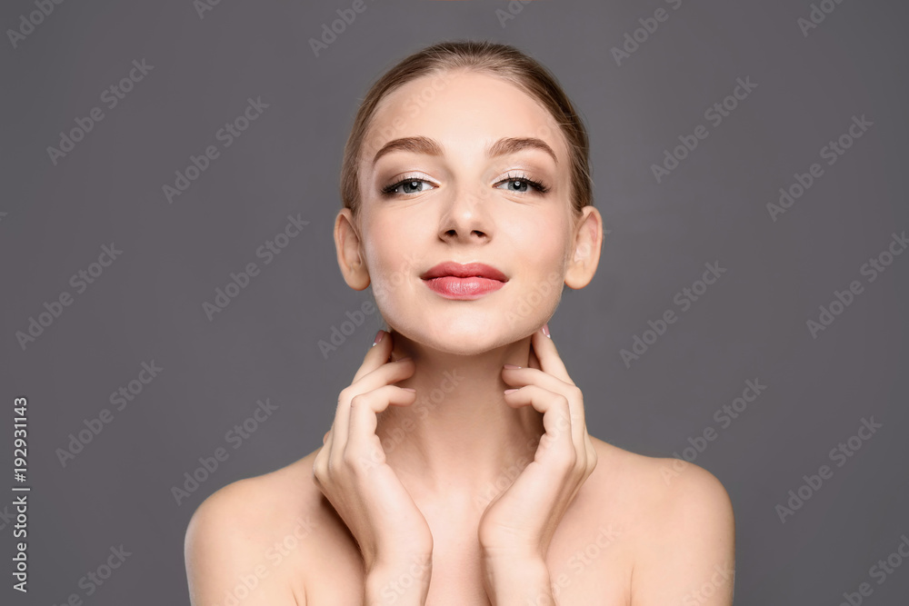 Portrait of beautiful young woman with clear skin on grey background Portrait of beautiful young woman with clear skin on grey background