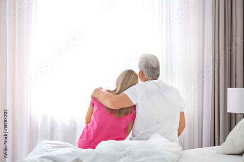 Mature couple sitting on be...