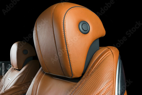 Modern Luxury car inside. Interior of prestige modern car. Comfortable leather seats. Orange perforated leather cockpit with isolated Black background. Modern car interior details © Aleksei