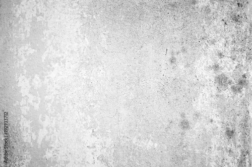 Weathered and aged concrete wall with paint mostly peeled off in black and white with vignetting.