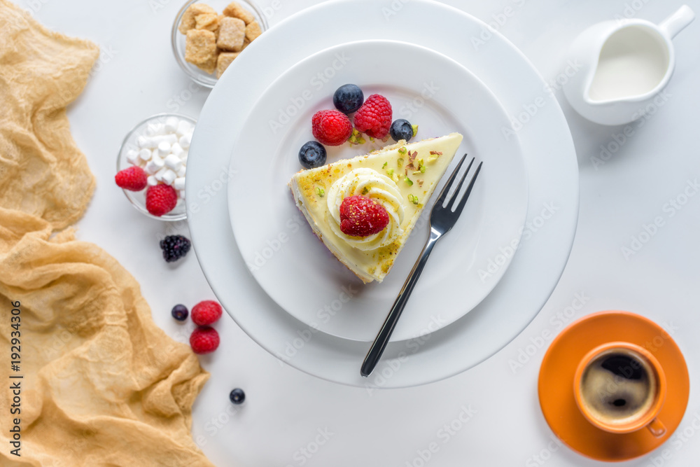 top view of piece of cake with berries on white table