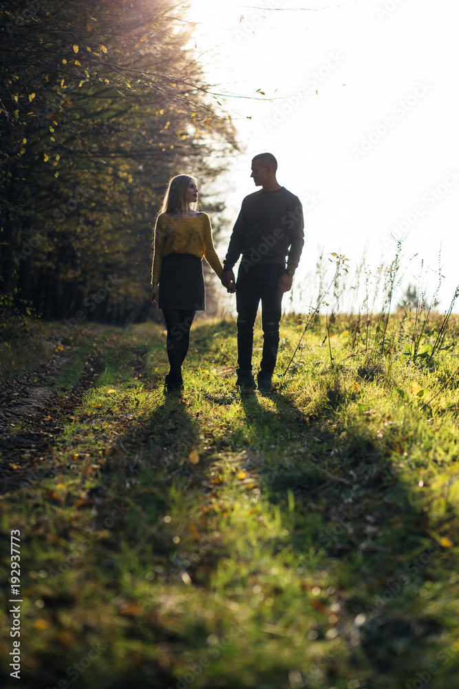 The lovely couple in love walking along park The lovely couple in love walking along park