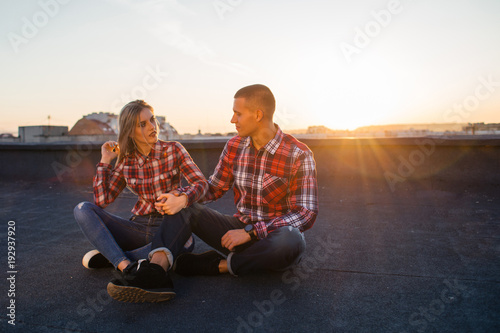 The lovely couple in love sitting on the roof