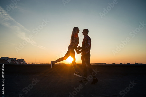 The lovely couple in love standing on the roof