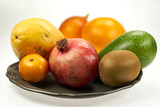 Owoce egzotyczne - granat, papaja, mango i inne na metalowym talerzy, na białym tle 