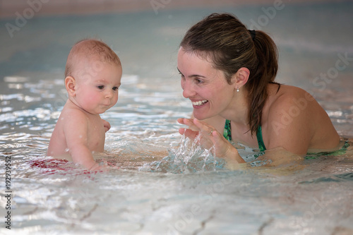 Little cute baby boy, swimming happily in a shallow pool water © Tomsickova