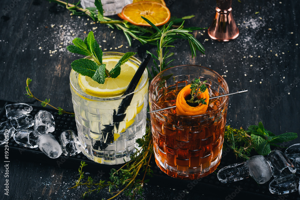Two Alcoholic Cocktail Gin and Tonic, Negroni. On a black wooden background. - obrazy, fototapety, plakaty 