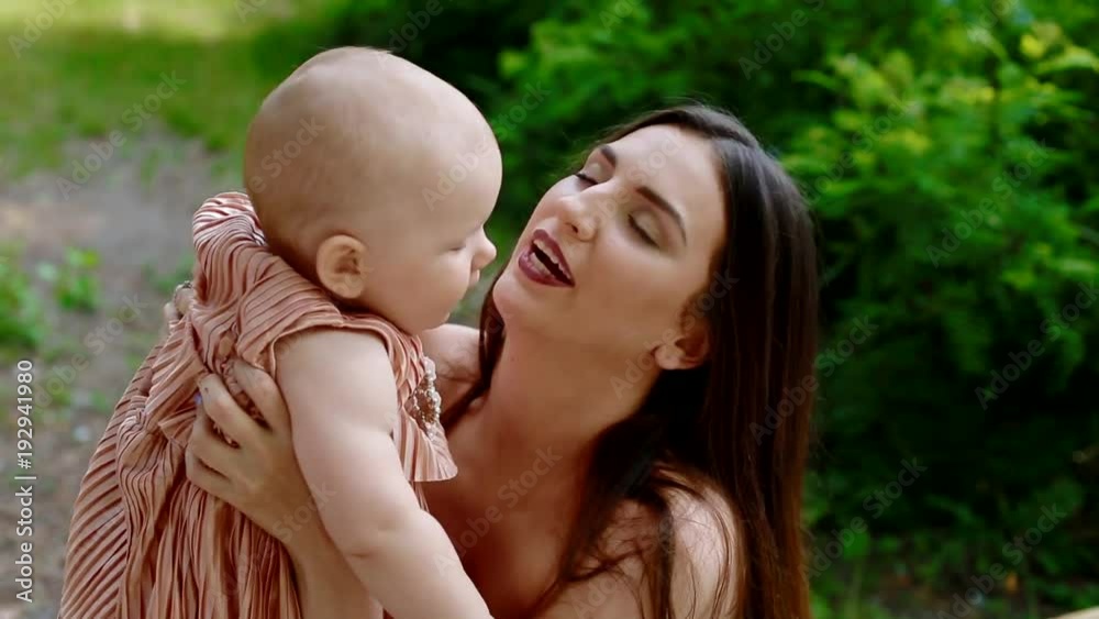 Young white woman playing with her little daughter. Girl kissing her mother. Closeup shot. Young white woman playing with her little daughter. Girl kissing her mother. Closeup shot.