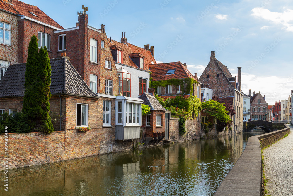 Typical view of Bruges (Brugge), Belgium with red brick houses with triangle shaped roofs and canals
