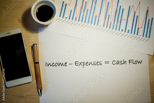 Photography Cash flow statement printed on a white sheet of paper and business charts on a m