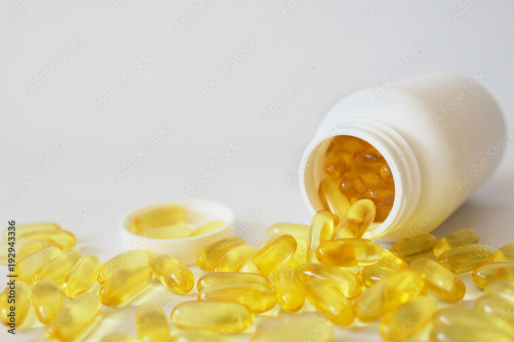 

Capsules of cod-liver oil in a white jar. Omega 3


