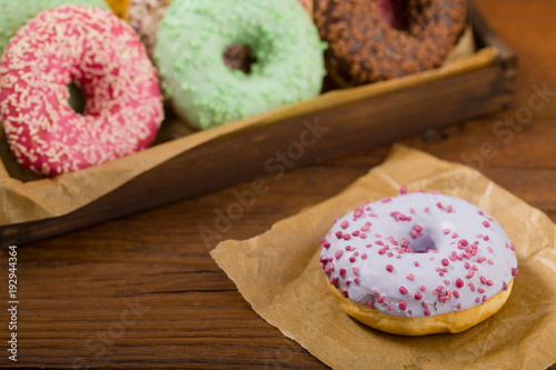 Colorful donuts on a wooden background.