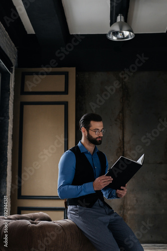 fashionable elegant businessman reading notebook in loft interior