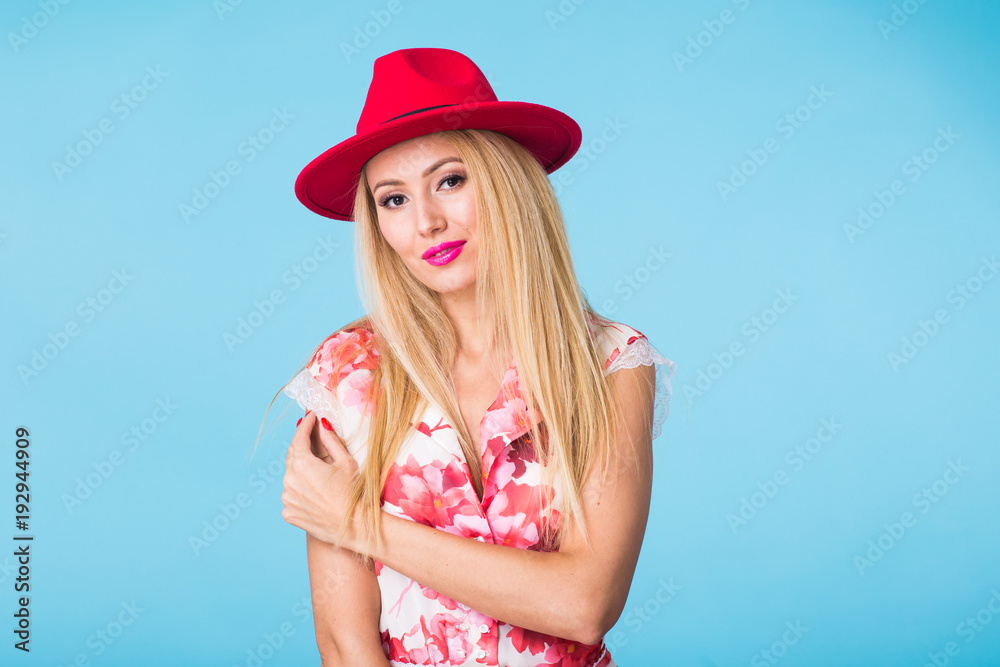 beauty fashion summer portrait of blonde woman with red lips and pink dress on blue background with copy space