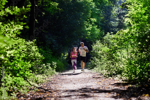 Konstfotografi Athletic man and woman doing Jogging in the woods.