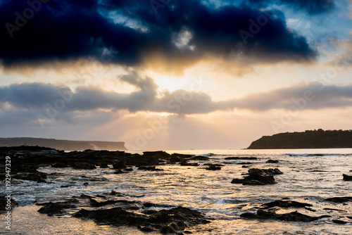 Dark clouds with sunrise over harbour