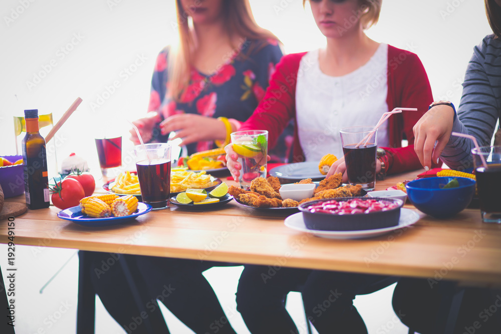 Top view of group of people having dinner together while sitting at wooden table. Food on the table. People eat fast food. Top view of group of people having dinner together while sitting at wooden table. Food on the table. People eat fast food.