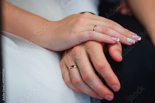 hands of newlyweds in love with gold rings at the wedding closeup
