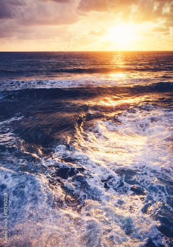 Fantastic stunning colorful sunset by the sea, waves and sunlight