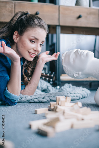 woman playing blocks wood game with layman doll near by at home, perfect relationship dream concept