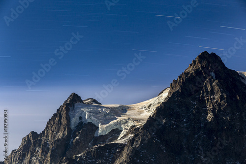 Filé d'étoiles au-dessus du Mont Pelvoux (3932m) et le glacier du Pelvoux éclairé par une nuit de pleine lune, région du Briançonnais, Hautes-Alpes © IMAREVA