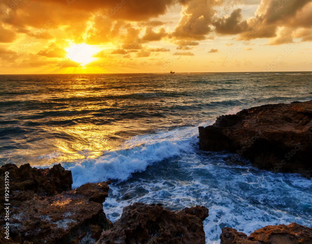 Fantastic stunning colorful sunset by the sea, waves and sunlight