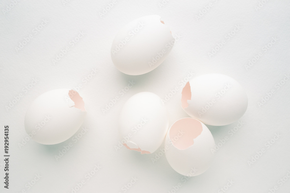 Creative pastel background with white eggshells on white background.