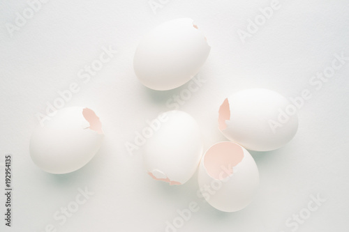 Creative pastel background with white eggshells on white background.