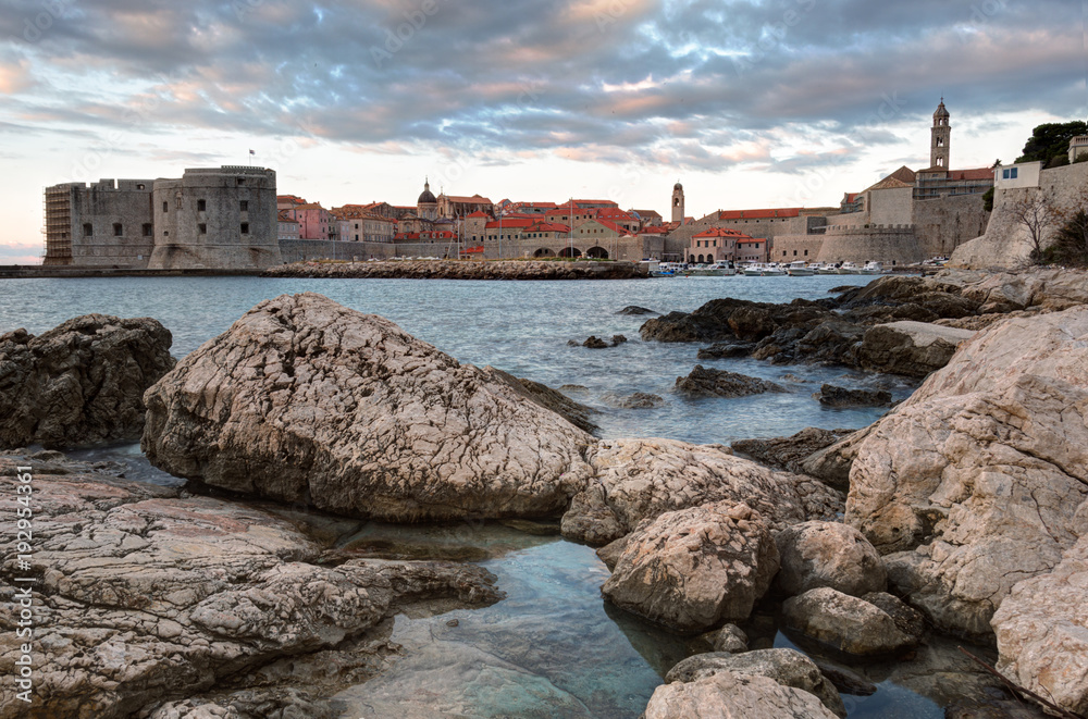Sunrise in Dubrovnik, a landscape overlooking the old town and large stones in the foreground, Croatia