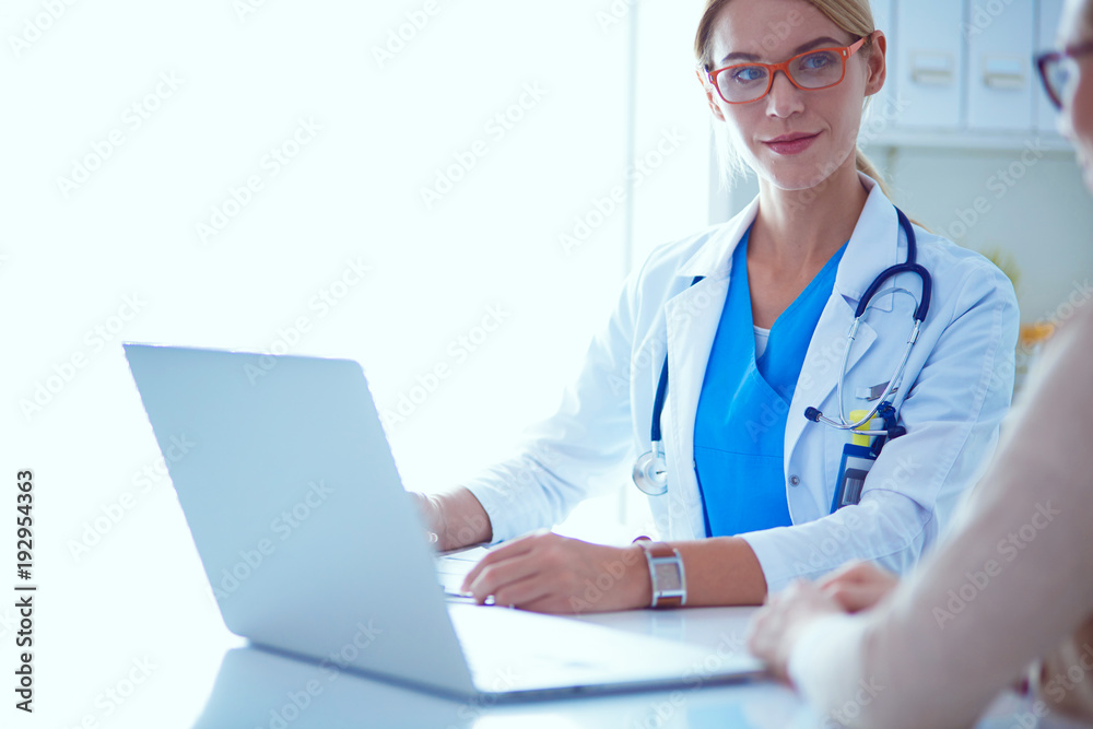 Doctor and patient couple are discussing something,sitting on the desk.