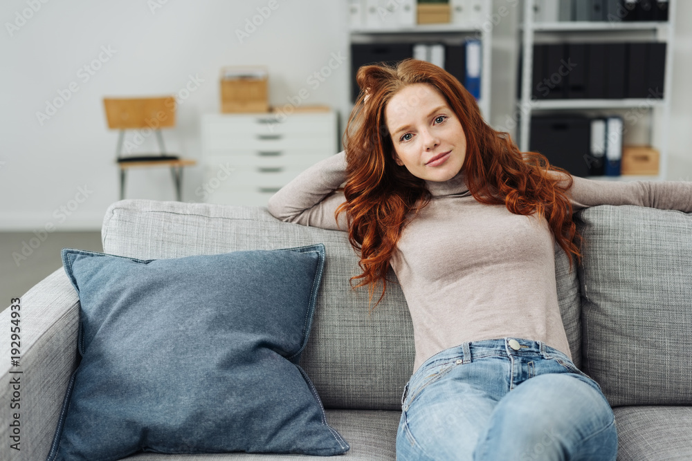 Obraz premium Young woman sitting on comfortable sofa