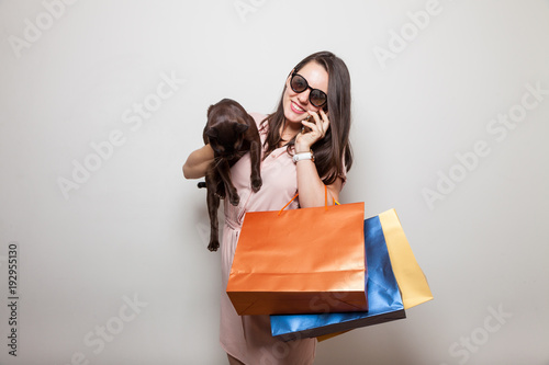 Beautiful smiling girl playes with cat holding color gift bags photo