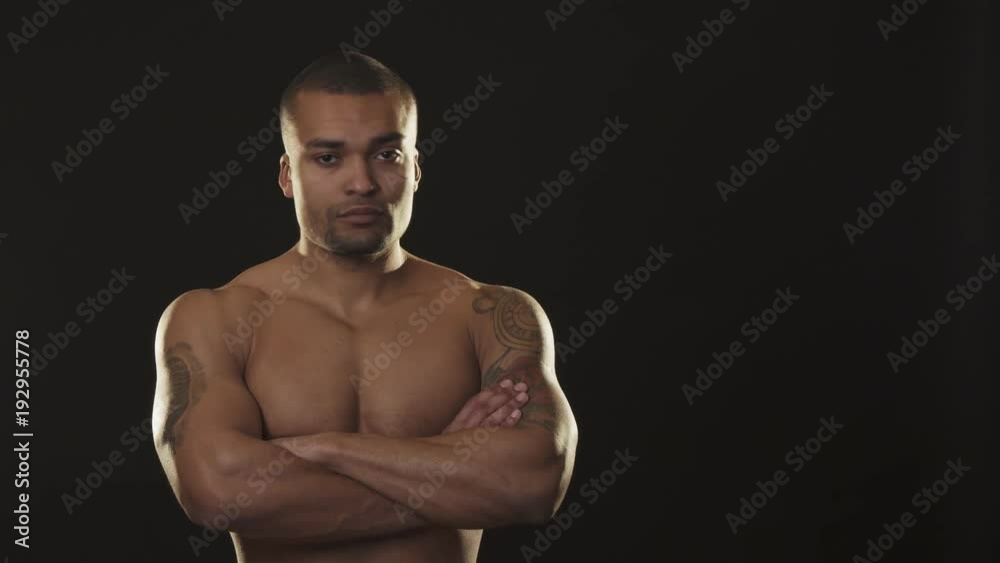 Handsome muscular athletic African man looking fiercely with arms crossed Handsome muscular athletic African man looking fiercely with arms crossed
