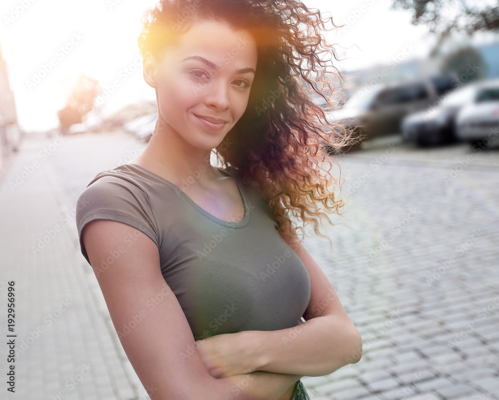 Fototapeta premium Young woman with afro hairstyle smiling in urban background