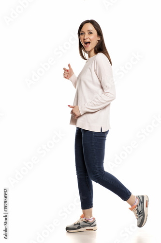 Profile of happy woman walking on white background