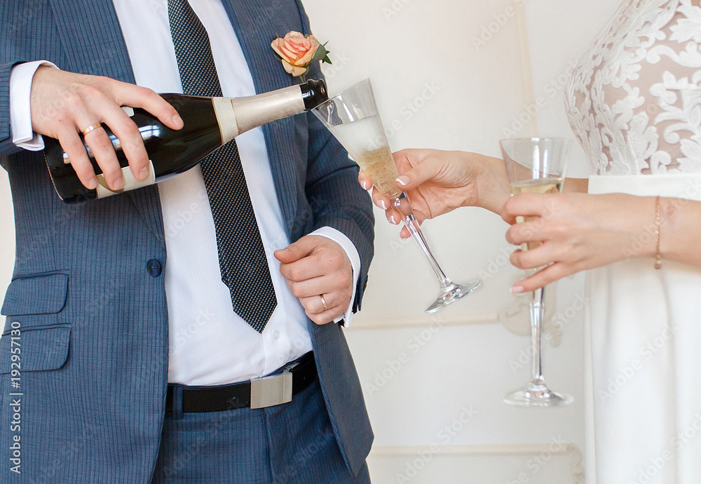 Fototapeta premium groom pouring the champagne to the bride