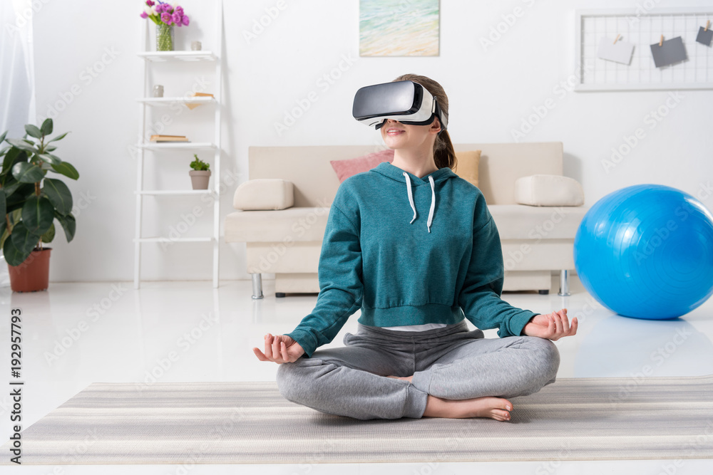 girl sitting in lotus position with virtual reality headset at home girl sitting in lotus position with virtual reality headset at home