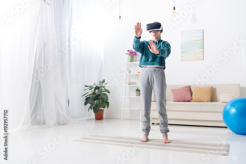girl touching something with virtual reality headset at home
