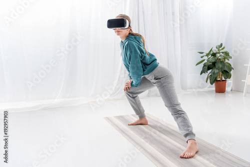 girl stretching legs with vr headset on yoga mat at home