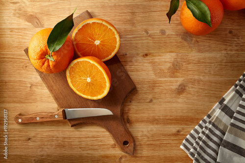 Arance fresche su tagliere per la preparazione di una nutriente spremuta photo