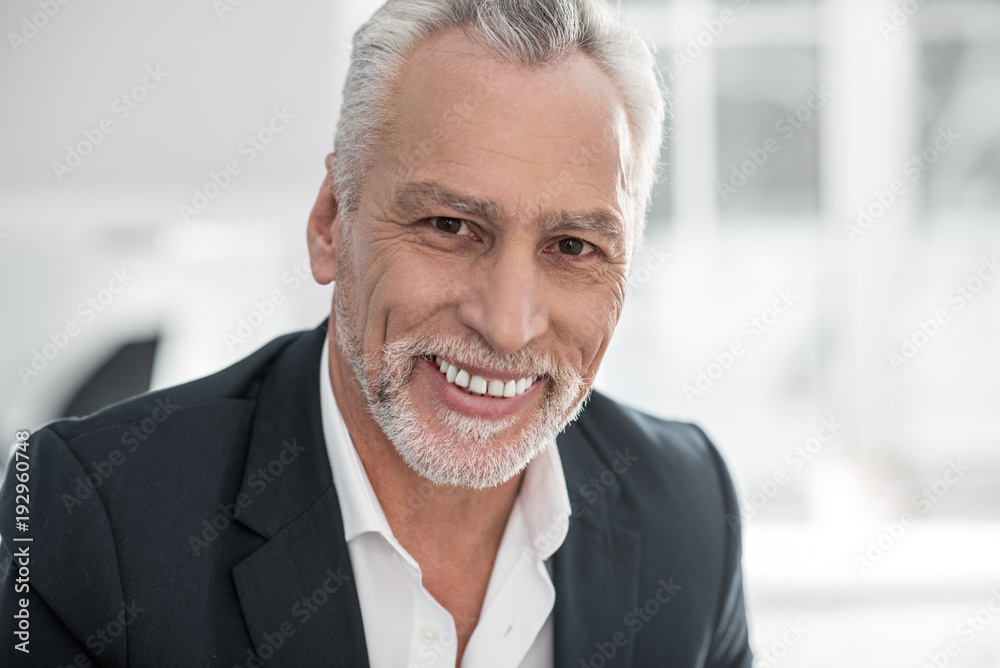 Watching you. Handsome pensioner keeping smile on his face and showing his emotions while being at home Watching you. Handsome pensioner keeping smile on his face and showing his emotions while being at home