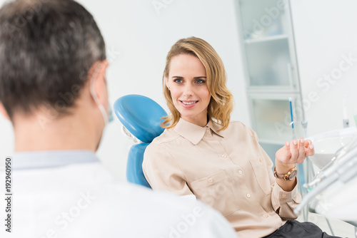 Woman consulting with doctor in modern dental clinic