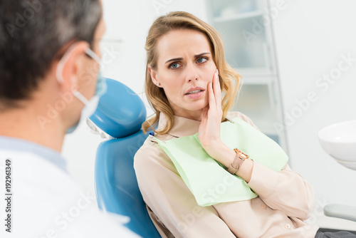 Female patient concerned about toothache in modern dental clinic photo