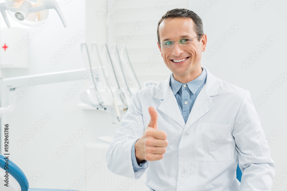 Dentist showing thumb up in modern dental clinic Dentist showing thumb up in modern dental clinic
