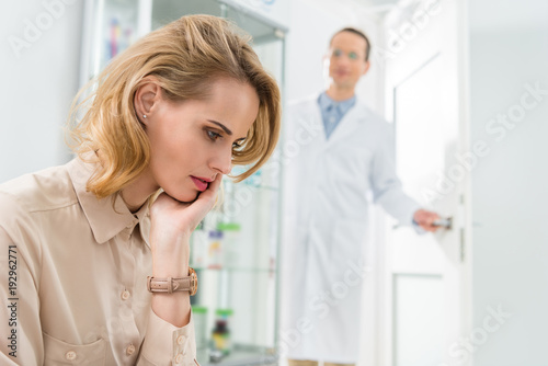 Doctor waiting for female patient suffering from toothache in modern dental clinic