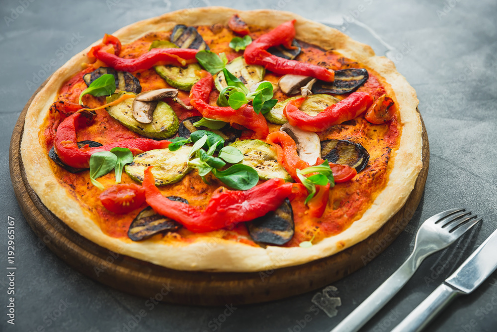 Vegetarian pizza with pepper, tomato, zucchini on dark background. Food background