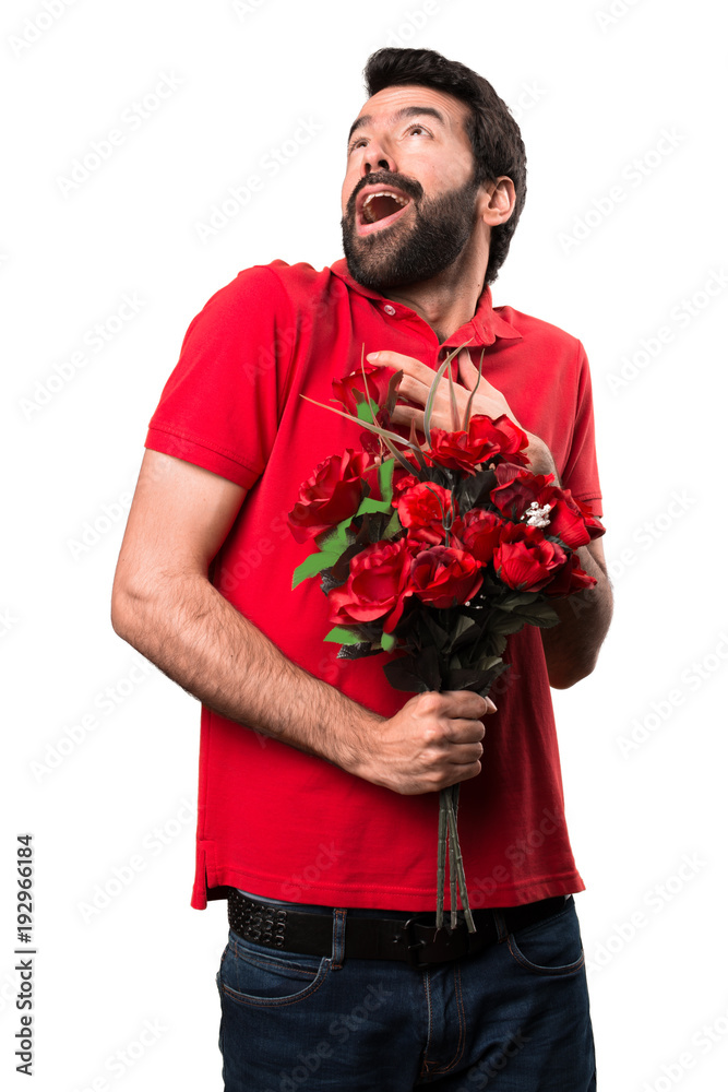 Handsome man holding flowers in love over white background Handsome man holding flowers in love over white background